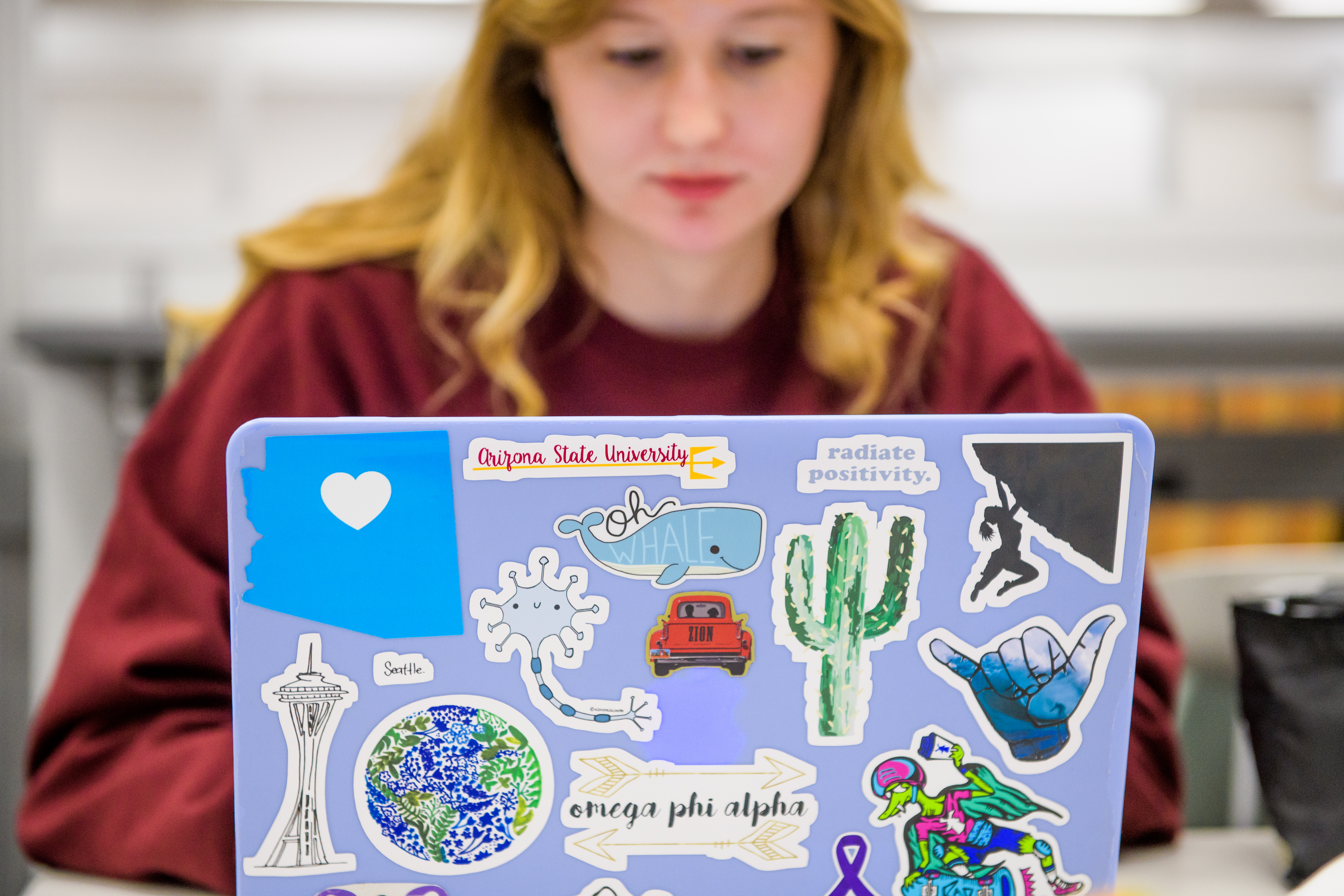Female student working on laptop with stickers